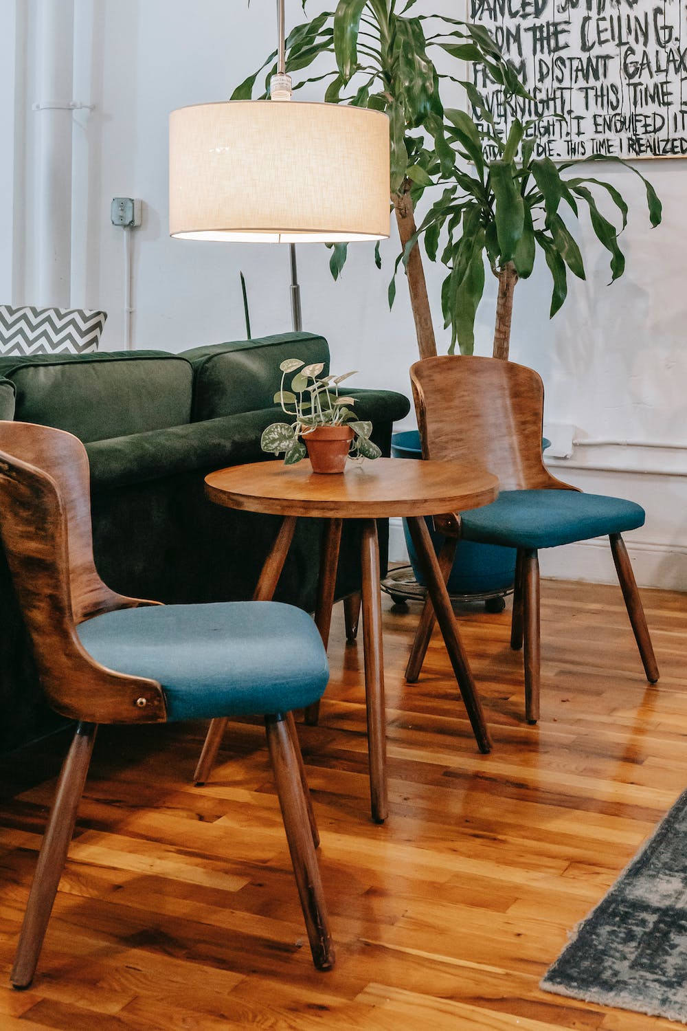 Wooden Chairs and Table Behind Green Colour Sofa